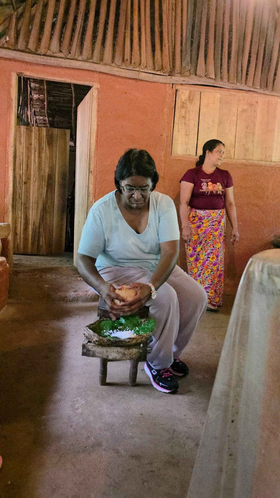 Guest grinding spices at a village cooking class